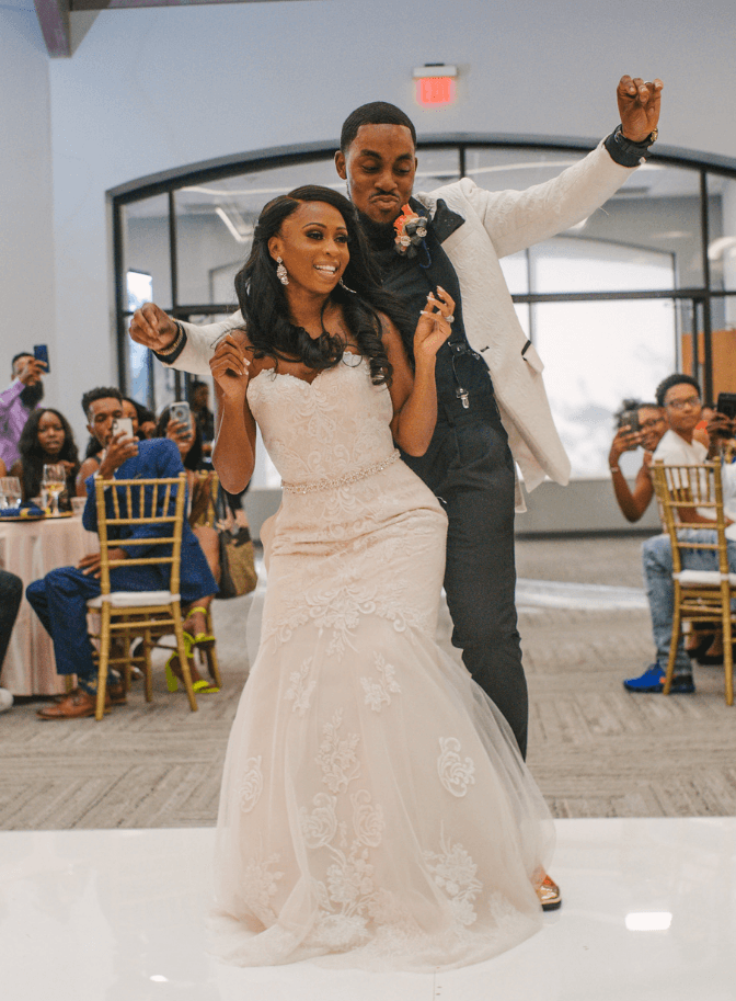 Bride and groom dancing at their reception as guests watch