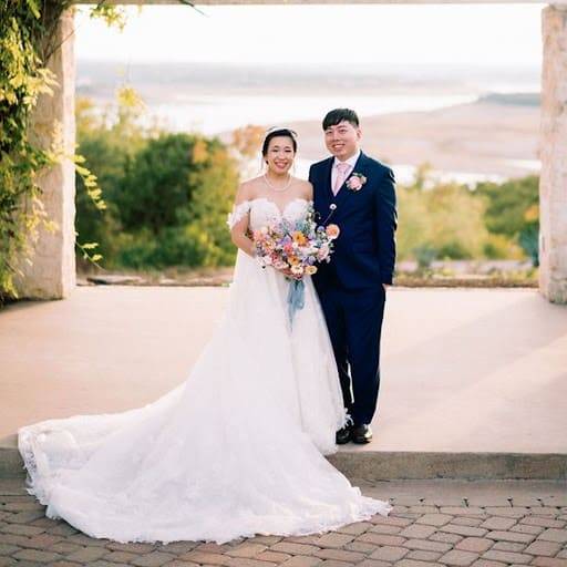 Bride and groom on a stone terrace overlooking the water