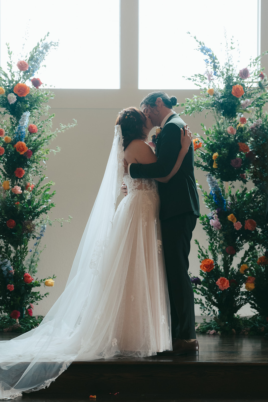 Bride and groom at the altar between floral columns